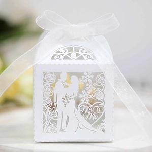 Close-up of laser-cut wedding candy box with Mr & Mrs text and white organza ribbon