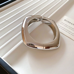 Macro detail of silver square bangle with polished mirror finish and hinged closure