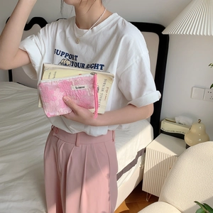 Detailed pink floral embroidery zipper pouch held by model for daily storage