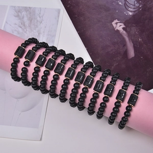 Detailed display of 12 zodiac black matte onyx bracelets with gold astrological charms