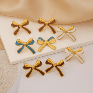 Detail of enamel bow stud earrings in brown blue and white with gold plated finish