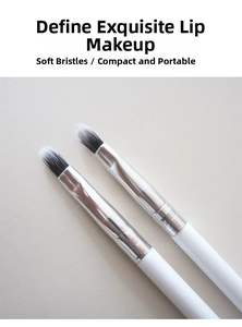 Detail showing two round silicone lip brushes with black and white gradient bristles