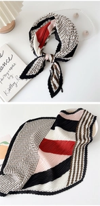 Detail of pleated silk scarf featuring geometric patterns in black, red, and brown colors