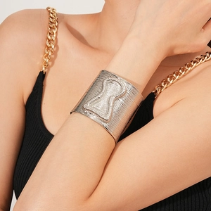 Detail of silver textured wide open cuff bracelet with linear pattern and embossed design