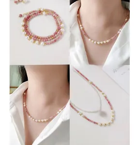 Detail of handmade necklace with pink natural stones, freshwater pearls and gold beads