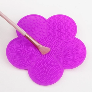Detail of purple silicone flower makeup brush cleaning mat with various textures