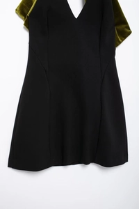 Détail d'une robe sans manches à col en V avec des nœuds en velours vert olive aux épaules
