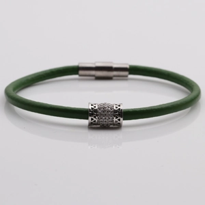 Dettaglio bracciale in pelle intrecciata verde con chiusura magnetica argento e zircone