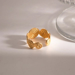 Detail of golden spiral textured open ring with elegant lighting and glass shadows