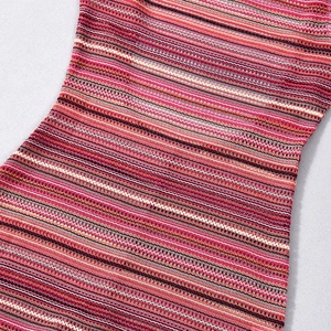 Detail of pink-orange striped knit fabric with hollow-out pattern on a romper