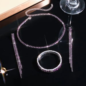 Detailed view of silver necklace bracelet and earrings set with purple rhinestones