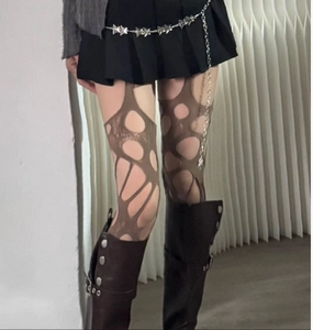 Detail of distressed brown torn fishnet stockings with subculture fashion styling