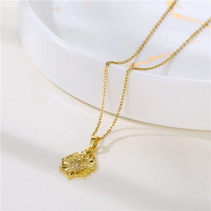 Collana con ciondolo a sole placcata oro 18 carati con zirconi su vassoio di marmo
