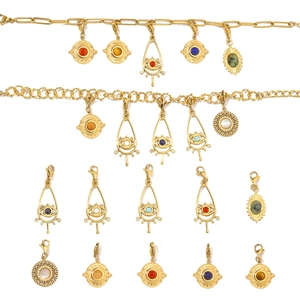 Macro detail of gold stainless steel charms featuring evil eyes and sun motifs with gems