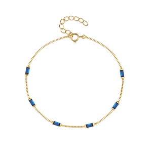 Detail of adjustable gold box chain bracelet featuring rectangular blue zircon stones