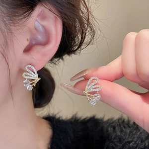 Detailed macro view of a delicate butterfly stud earring featuring gold plating and zircons