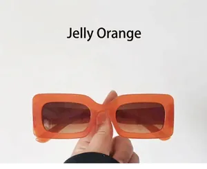 Detail view of retro jelly orange square sunglasses with gradient brown lenses