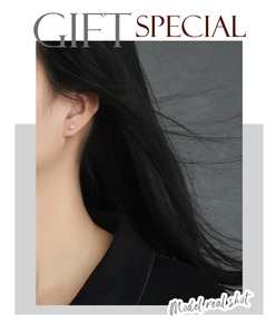 Detail of minimalist silver stud earring with blue square zircon on model's ear