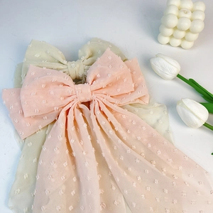 Detailed view of layered chiffon bow clips with elegant polka dot texture and long ribbons