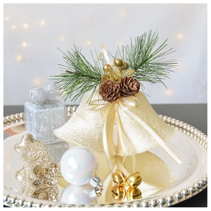 Detail of gold Christmas bells with pine cones and needles on a festive silver tray