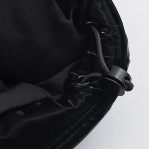 Close-up of waterproof glossy black fabric with adjustable drawstring and toggle detail