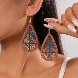 Close-up of bohemian water drop wood earrings with colorful floral acrylic patterns