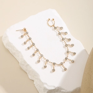 Golden fringe chain earring with sparkling rhinestones on a white natural stone base