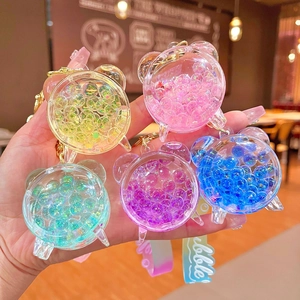 Dettaglio di portachiavi colorati con bolle liquide, cinturini in silicone e anelli d'oro