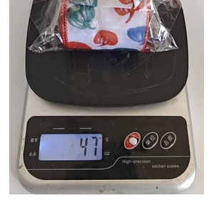 Détail montrant le poids de 47g du ruban décoratif imprimé sur une balance numérique