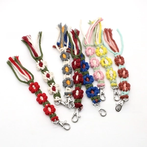 Detailed view of handmade woven flower keychains in multiple vibrant color combinations