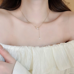 Détail du collier doré avec pendentif croissant de lune et étoile sur le cou