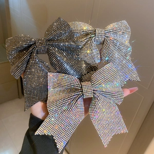 Close-up of sparkling full rhinestone bow hair clips in silver and gunmetal gray colors