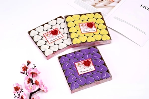 Macro shot of heart-shaped smokeless tea light candles in purple, yellow and white colors