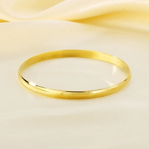 Detailed view of a 5.5mm wide 18K gold plated polished stackable titanium steel bangle