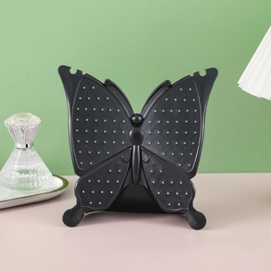 Black butterfly jewelry stand for earrings and necklaces on green and pink background
