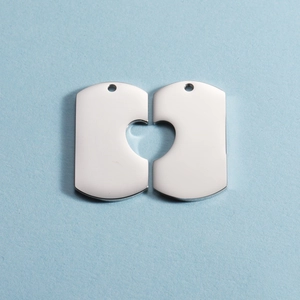 Polished stainless steel heart-puzzle keychain pendants for couples on a light blue background