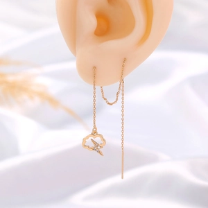 Detail of gold cloud and lightning bolt earrings with sparkling zircon on ear model