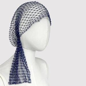 Detail of dark blue mesh headpiece with sparkling rhinestones on a white mannequin