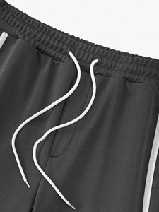 Detail of high-quality charcoal gray sweatpants with elastic waist and white drawstring