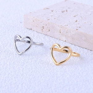 Minimalist open heart rings in gold and silver finish on a textured stone surface