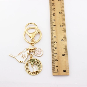 Japanese sakura cat keychain with enamel flower charms and measurement ruler on white background