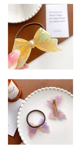 Close-up of marble pattern acetate bow hair tie and clip with pearl center decoration