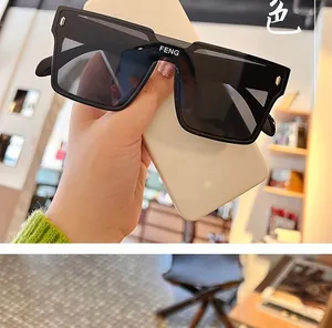 Macro detail of black square sunglasses featuring silver rivets and FENG logo on the bridge