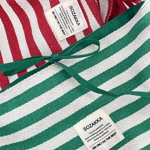Gros plan détaillé du tissu en toile rayée avec étiquette tissée SOZAKKA et coutures nettes
