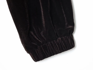 Dettaglio del polsino elastico sul completo sportivo in velluto marrone scuro da donna