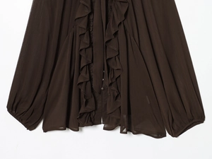 Detail of ruffled placket and tie-neck on a dark brown chiffon blouse for women