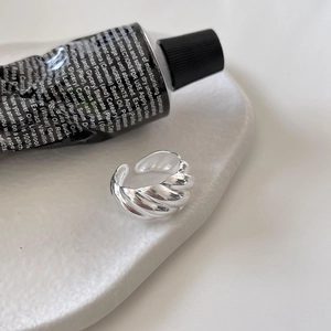 Close-up of a 925 sterling silver croissant ring with twisted texture on a white tray