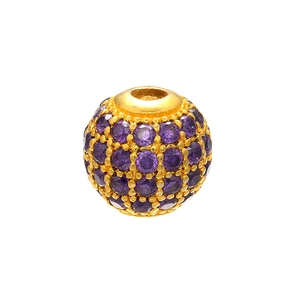 Macro shot of a gold-plated spherical bead with micro-pave set purple cubic zirconia gems