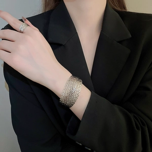Silver multi-layer cuff bracelet and ring set shown on model in black blazer