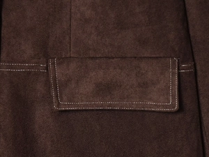 Detailansicht der dunkelbraunen Wildlederjacke mit weißen Kontrastnähten an der Tasche